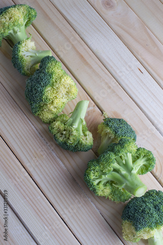 green healthy broccoli on light wood