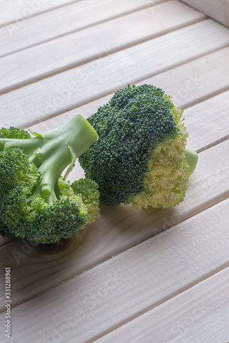 green healthy broccoli on light wood