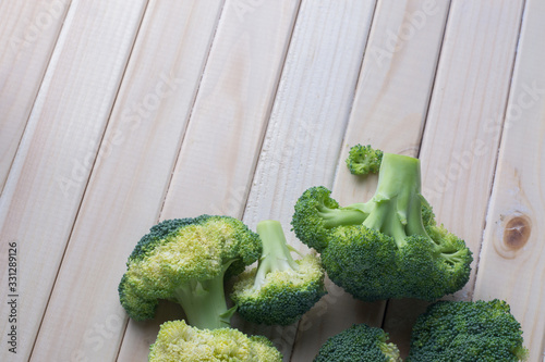 green healthy broccoli on light wood