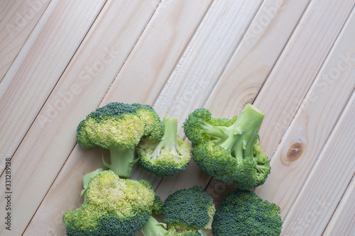 green healthy broccoli on light wood
