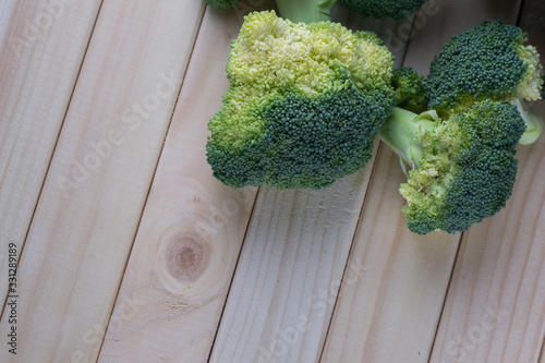 green healthy broccoli on light wood