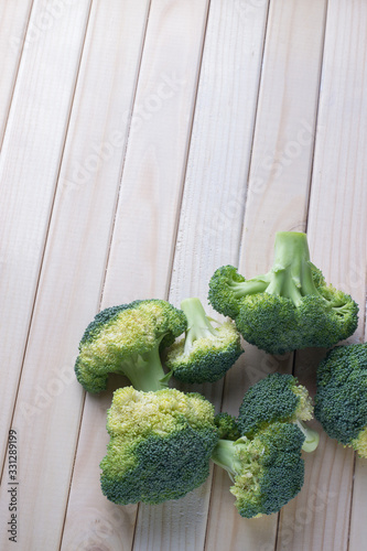 green healthy broccoli on light wood