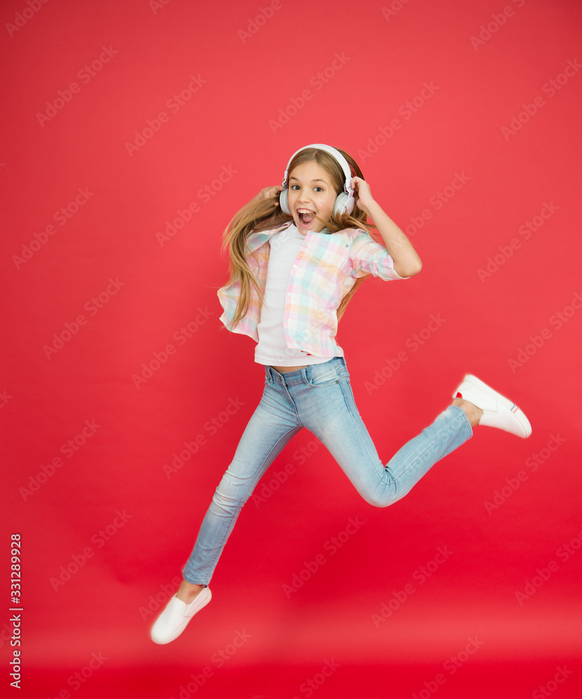 reach her dream. fly up in air. achievement. excited small girl wear headphones. show dance move. childhood happiness. happy kid listen music. child having fun. Little girl in earphones