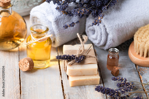 Concept of natural organic oil in cosmetology. Moisturizing skin care and aromatherapy. Gentle body treatment. Atmosphere of harmony relax. Wooden background, lavender flower, wooden brush, soap