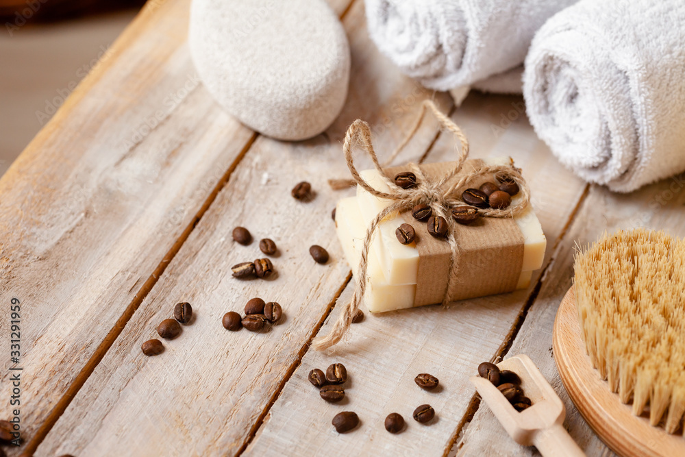 Naklejka premium Concept of home natural organic body care. Handmade soap bars with coffee used as gentle scrub. Brush to increase anti-cellulite effect. Relax, pleasant treatement. Close up macro, wooden background
