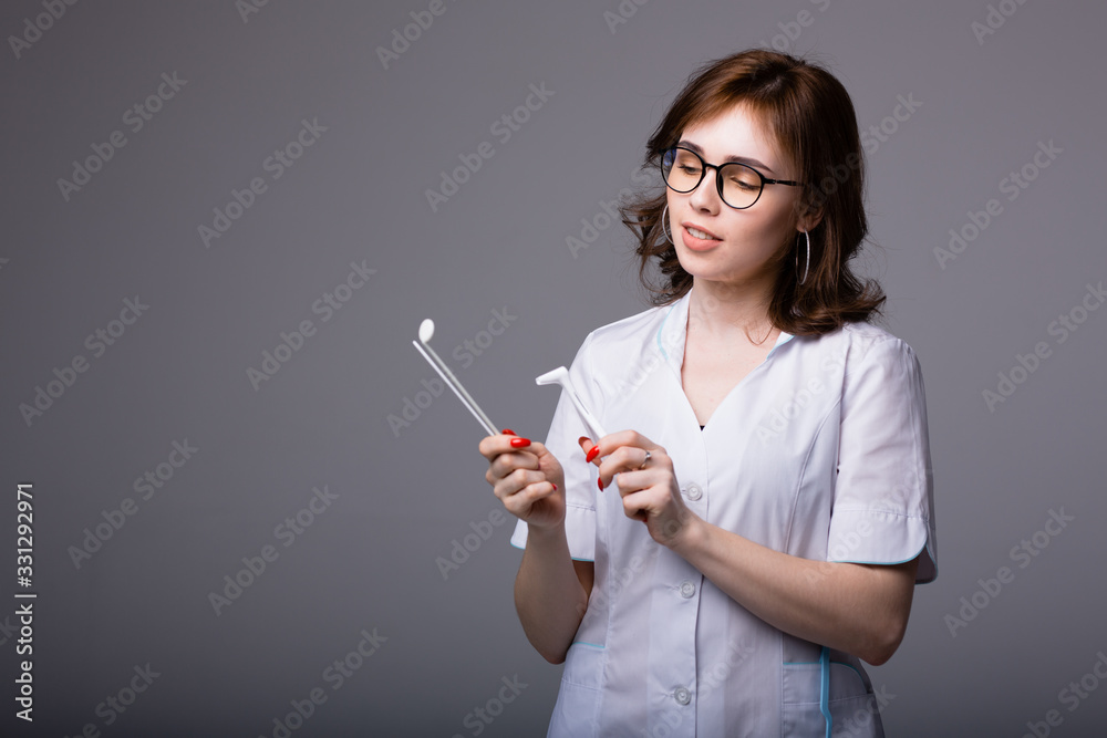 Attractive female doctor standing with tools to examine a patient with a suspected viral infection Attractive female doctor standing with tools to examine a patient with a suspected viral infection