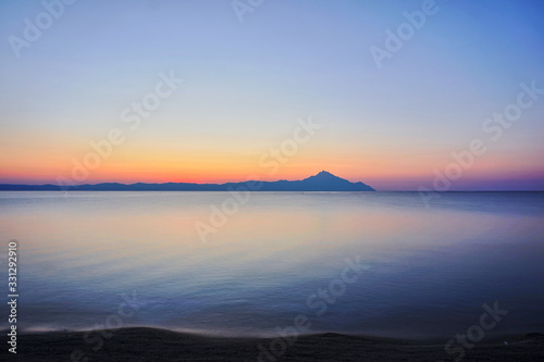 Wonderful sunrise view behind the mountains and next to the sea