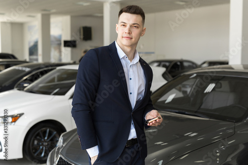 Handsome man choosing a car in a show room © Artem Zakharov