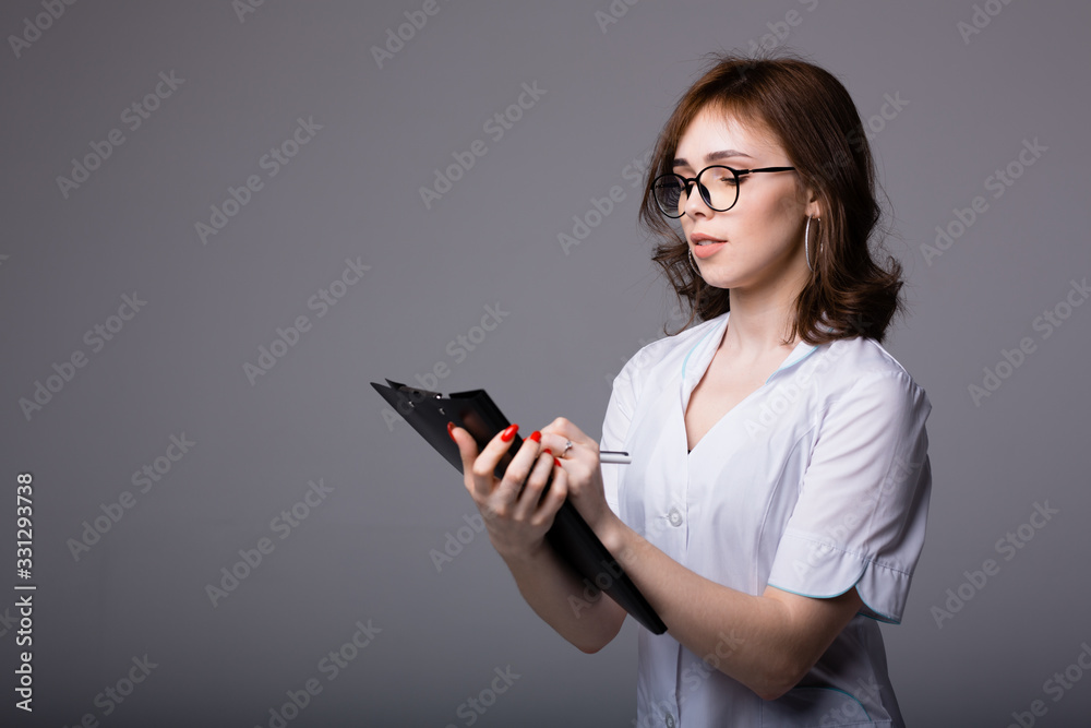 Attractive american doctor holding a black tablet with medical records of her patients Attractive american doctor holding a black tablet with medical records of her patients
