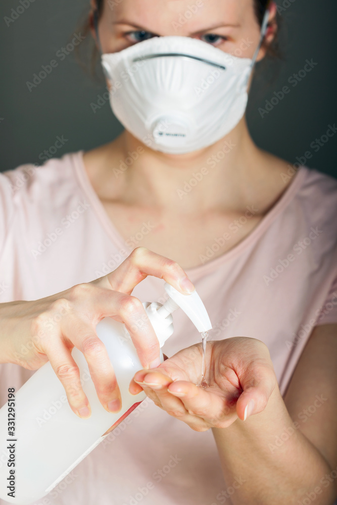 Close up woman using wash hand sanitizer gel dispenser, against Novel coronavirus (2019-nCoV) at home.