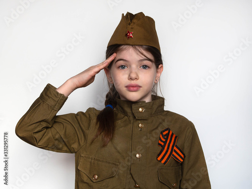 Obraz na płótnie Close-up portrait of a beautiful little russian girl in uniform isolated on white background. Holiday Victory Day in Russia in the Great Patriotic War. May 9th, concept w salonie