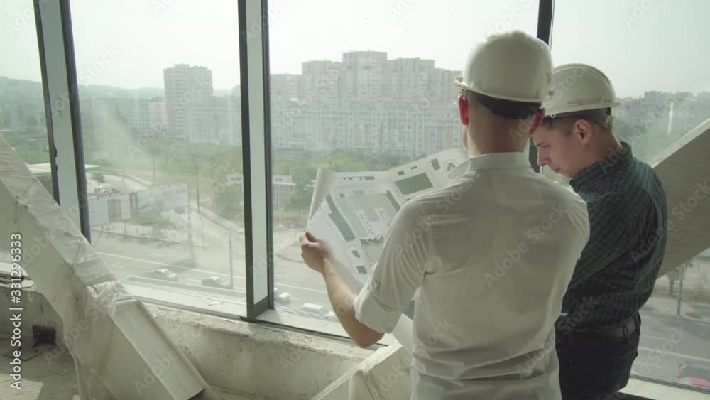 Two people responsible for the evacuation plan of the building check to see if everything fits Two people responsible for the evacuation plan of the building check to see if everything fits