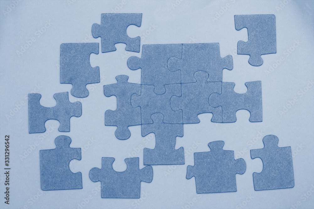 Unfinished puzzle pieces background toned in trendy color 2020 year classic blue. Top view. Unfinished puzzle pieces background toned in trendy color 2020 year classic blue. Top view.