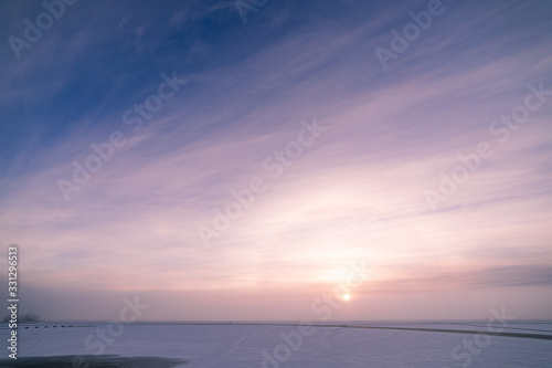 Sun through fog at lake winter morning