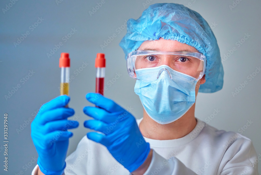 Doctor in mask holding the blood test tubes, coronavirus COVID19