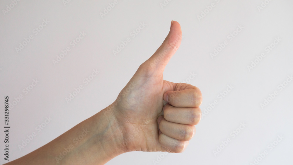 Female left hand. Thumb up on white background. OK gesture. Female left hand. Thumb up on white background. OK gesture.