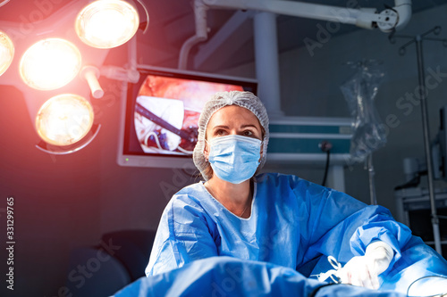 Quadro em tela Portrait of the professional medical assistant in surgical mask during operation
