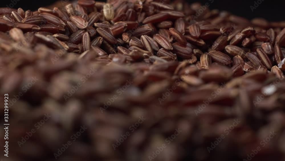 Brown rice lies on table and camera rotate around it. Rice is the main food for all people, macro footage Brown rice lies on table and camera rotate around it. Rice is the main food for all people, macro footage