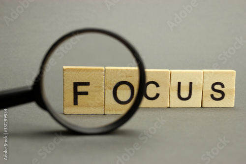 The word focus is made of wooden letters with a magnifying glass. Selective focus photo
