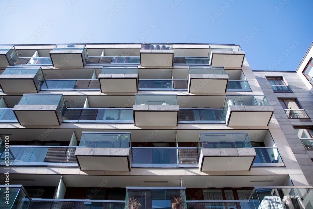 Exterior of new apartment buildings on a blue cloudy sky background. No people. Real estate business concept. Exterior of new apartment buildings on a blue cloudy sky background. No people. Real estate business concept.