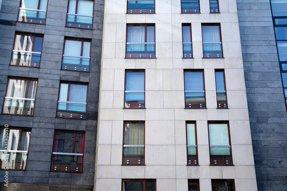 Exterior of new apartment buildings on a blue cloudy sky background. No people. Real estate business concept.