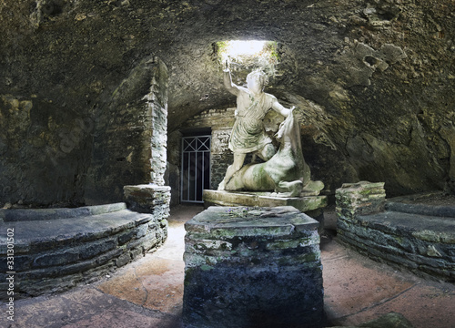 Immersive view of God Mithras statue in the act of killing bull to sacrifice it, the beautiful cave is located in the thermal s mithraeum in archaeological excavations of Antica Ostia in Rome, Italy