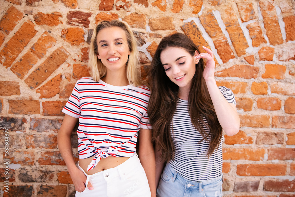 Portrait of two cheerful teenage girls posing to a camera. 