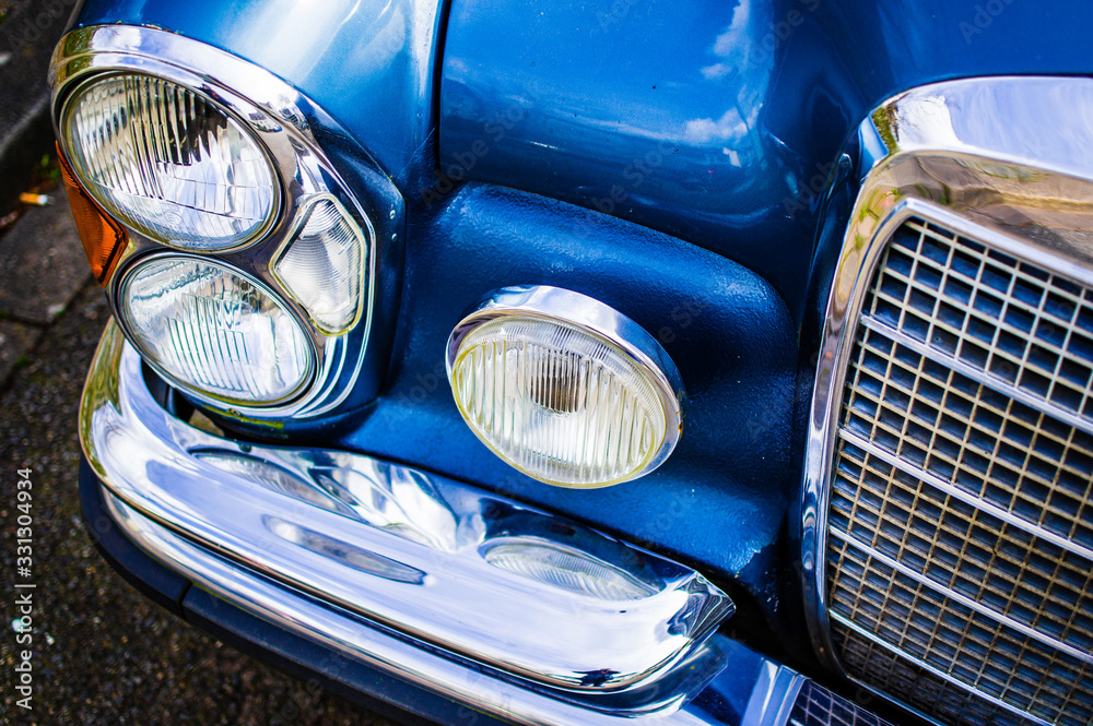 Alter Oldtimer in blau mit Kühlergrill und Lampen mit viel Chrome