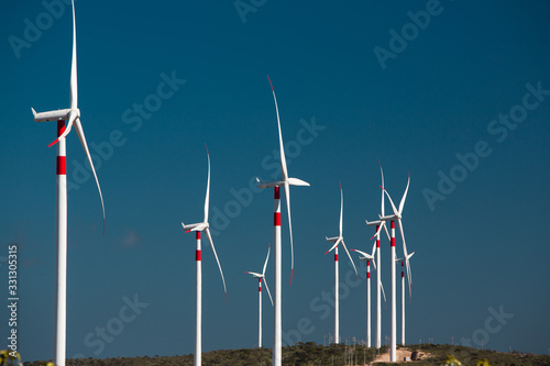 Panorama of a big wind farm on green meadow in front of blue sky