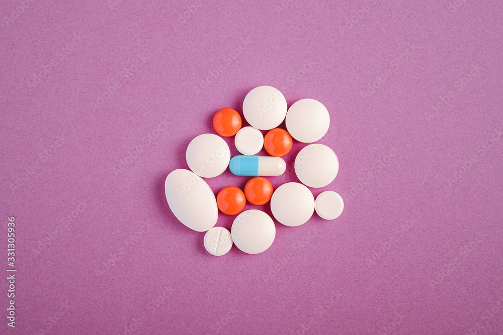 Pills and tablets on bright violet purple background, healthcare medical concept, antibiotics and cure, top view copy space