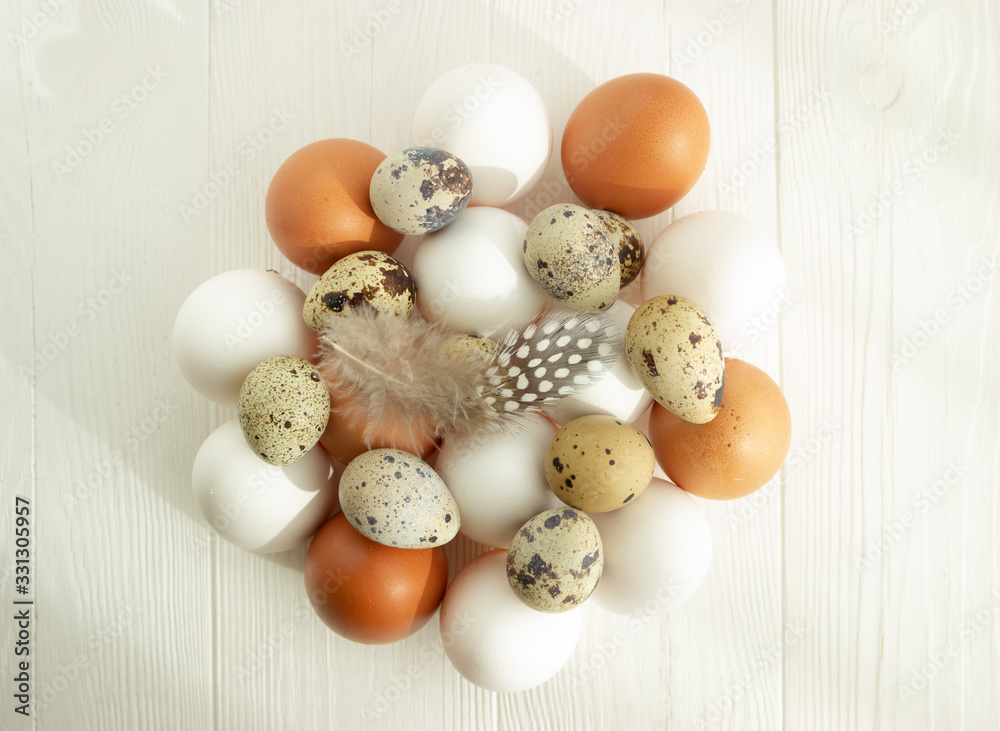 Easter. White and beige chicken and quail eggs on a white wooden background with space for text. flat location. Easter. White and beige chicken and quail eggs on a white wooden background with space for text. flat location.