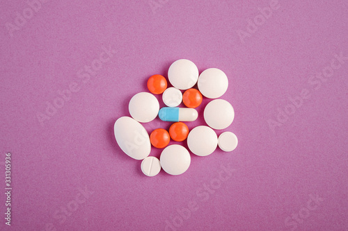 Pills and tablets on bright violet purple background, healthcare medical concept, antibiotics and cure, top view copy space