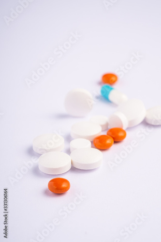 Pills and tablets on bright white background, healthcare medical concept, antibiotics and cure, angle view