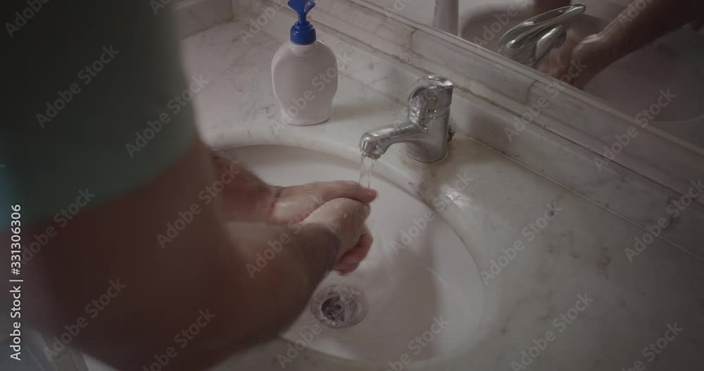 man washing his hands in bathroom man washing his hands in bathroom