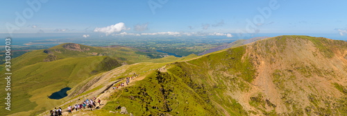 A panoramic view from the Snowdon summit with a blue sky and green mountains in North Wales, Gwynedd, UK © Juando González