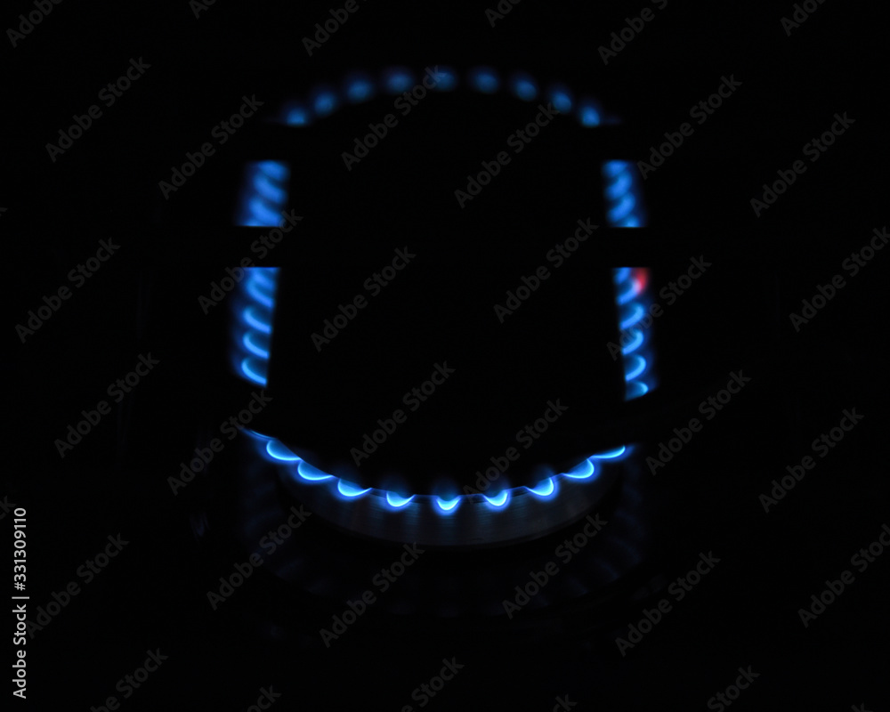Blue flames of natural gas burning stove top view from above with empty copy space