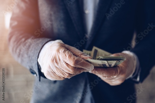 Man counting Polish zloty money banknotes in protective latex gloves. photo