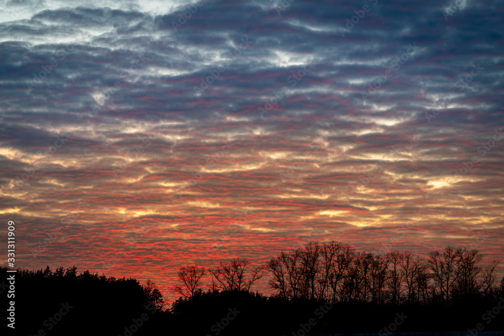 Spring sunset sky with clouds in red and blue