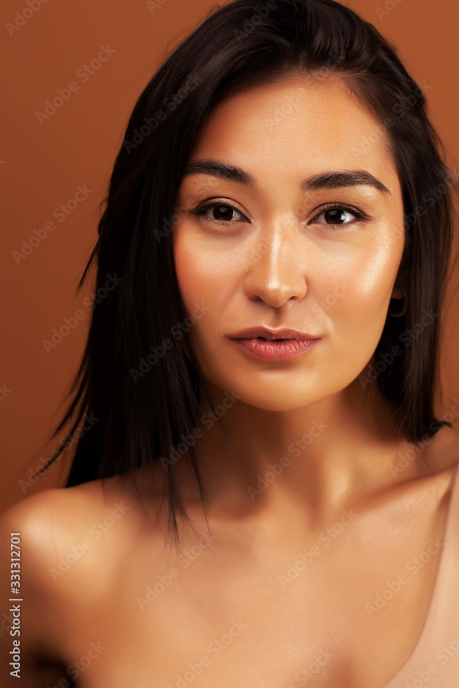 Naklejka premium young pretty asian woman cheerful smiling posing on warm brown background, lifestyle people concept