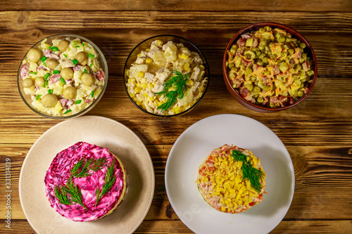 Set of festive mayonnaise salads on wooden table. Top view