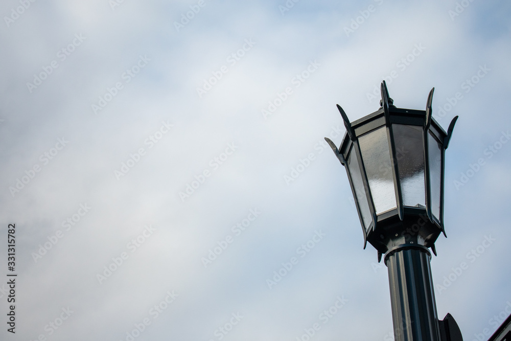 An Old Fashion Street Lamp Against a Cloudy Sky An Old Fashion Street Lamp Against a Cloudy Sky