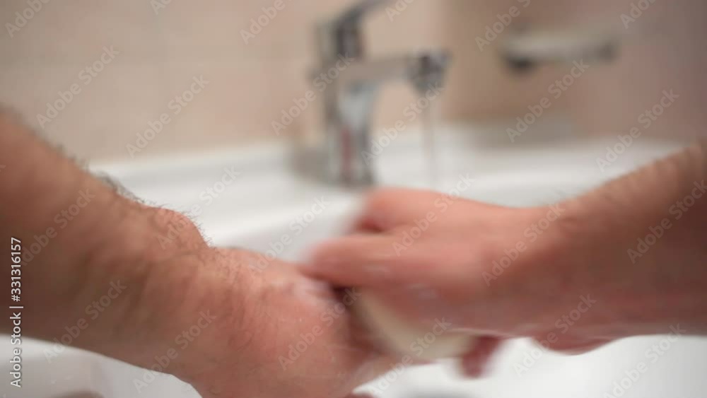Everyday hygiene in bathroom, man carefully washing hands with delicate soap, cleaning fingers and palms from microbe and bacteria. Hygiene rules in epidemic period of coronavirus expansion Everyday hygiene in bathroom, man carefully washing hands with delicate soap, cleaning fingers and palms from microbe and bacteria. Hygiene rules in epidemic period of coronavirus expansion