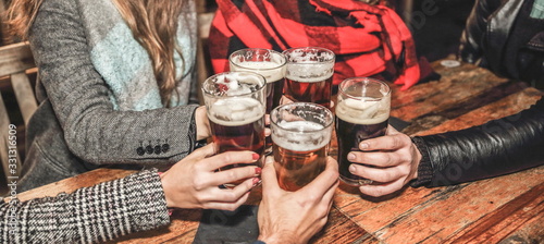 Diverse People Friends Hanging out together at the pub drinking beer concept. Londoners group of friends meet up in a pub. Group of happy friends drinking beer at brewery. Pints of glasses drinking.