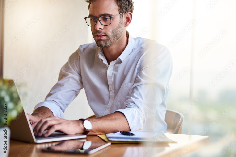 Young businessman working at his dining room table at home Young businessman working at his dining room table at home