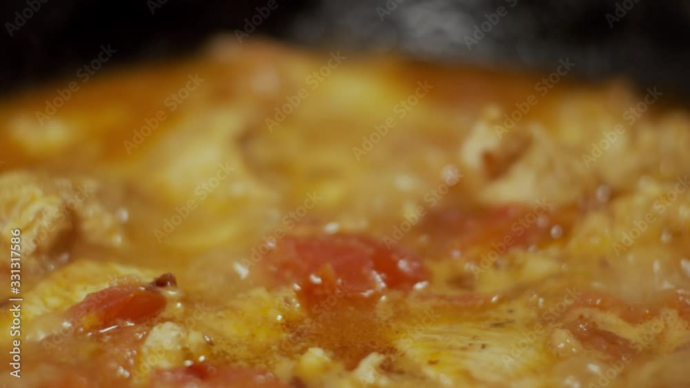 Chicken meat in frying pan, process of frying in oil, shallow depth of field, slow motion