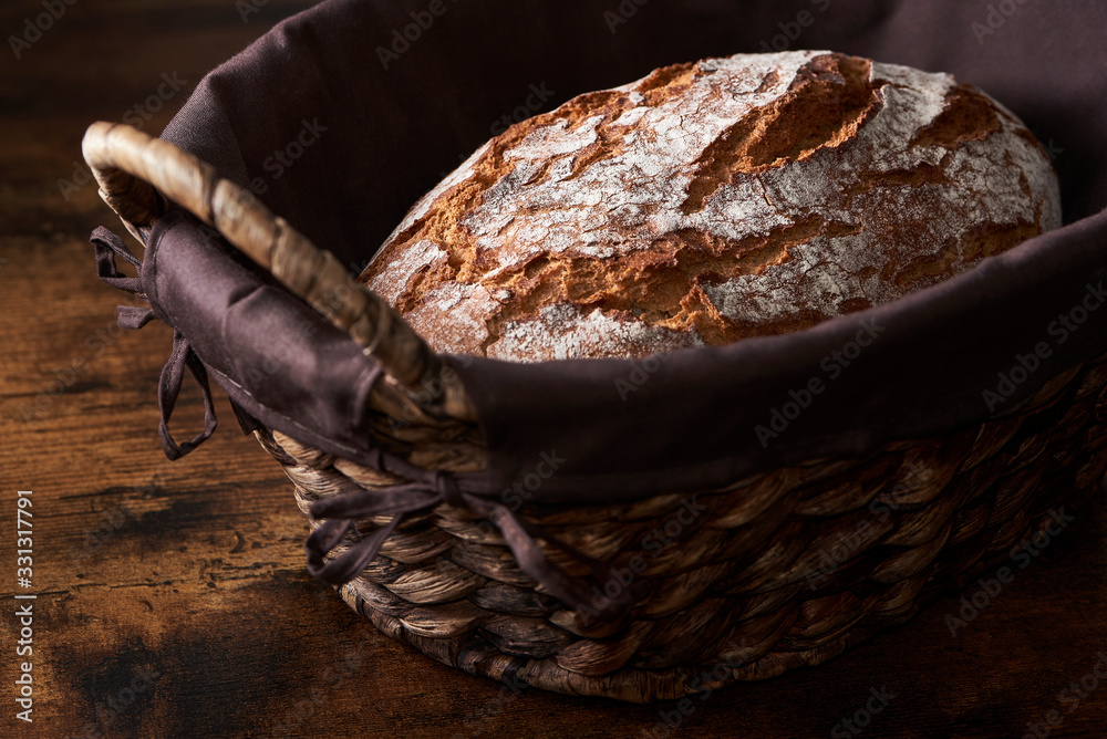 Fotografie Fresh crusty bread in braided basket