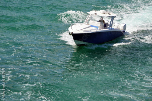 Angled overhead view of a sport fishing boat with covered center console n and four outboard engines. © Wimbledon