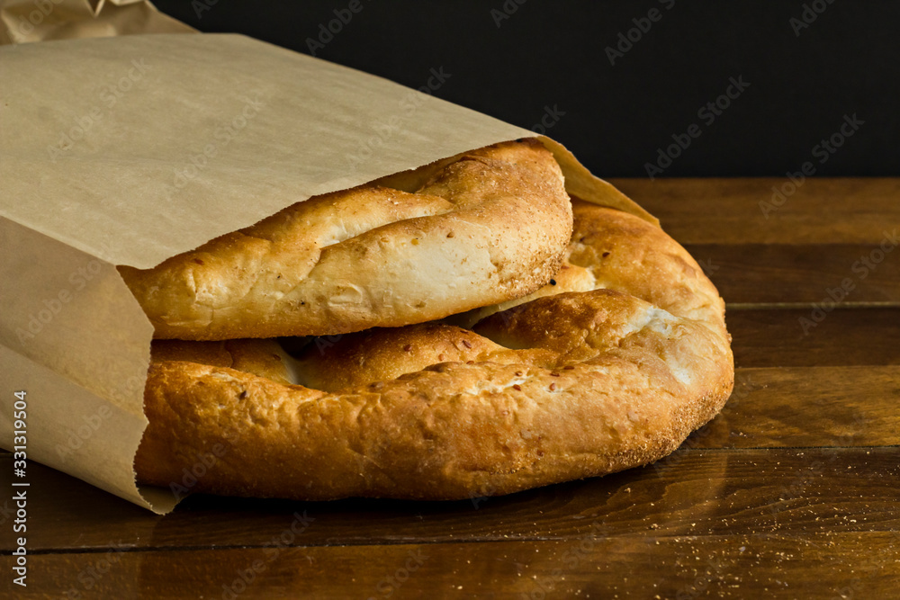 Traditional Turkish,Fresh,Circular Ramadan Bread in craft paper bag.Conceptual image of Ramadan.