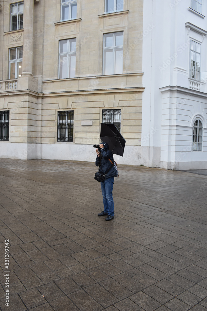 A photographer holds an umbrella and takes a picture