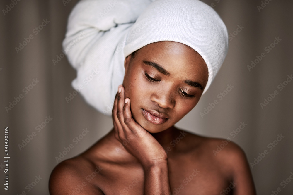 Young woman touching her cheek after washing her hair Young woman touching her cheek after washing her hair